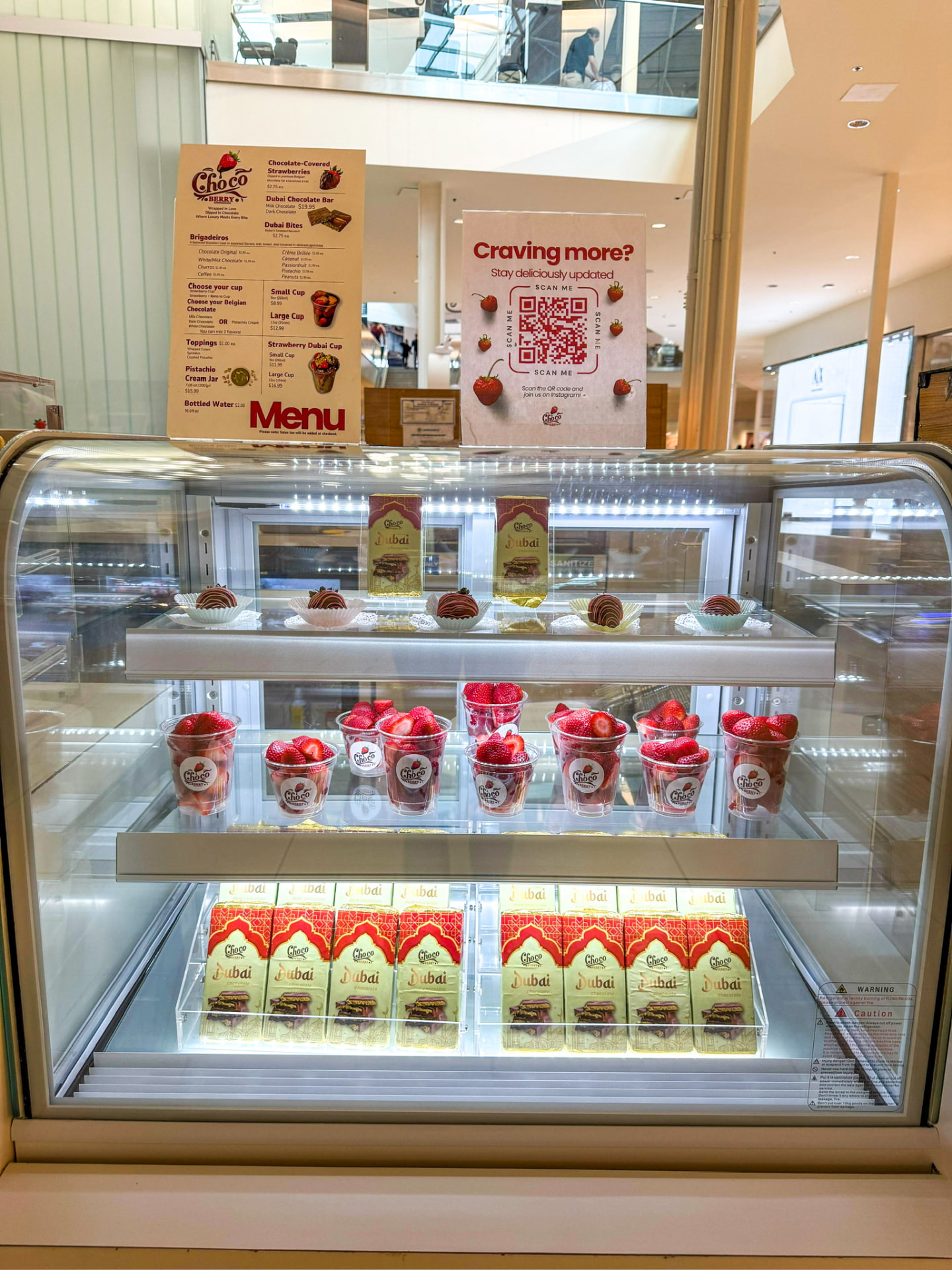 Vitrine refrigerada do quiosque Choco Berry com cardápios e produtos