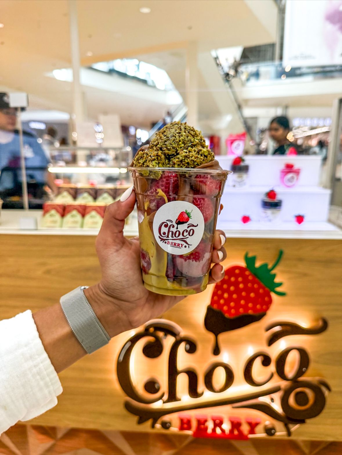 Copo de morangos com Dubai chocolate na frente do quiosque Choco Berry